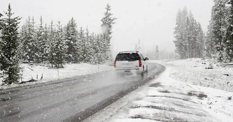 SUV driving on snowy road showing AWD capability