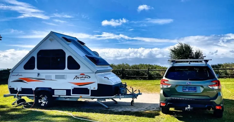 SUV towing a small camper trailer on a scenic road