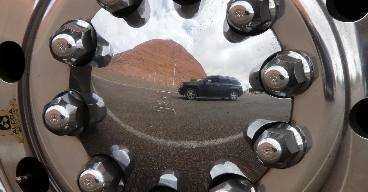 Close-up of chrome lug nuts on a heavy-duty truck wheel