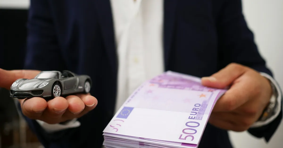 Toy car model next to cash representing a car loan approval