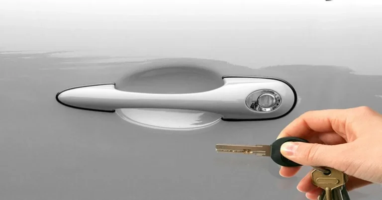 Hand holding rental car keys next to the door handle