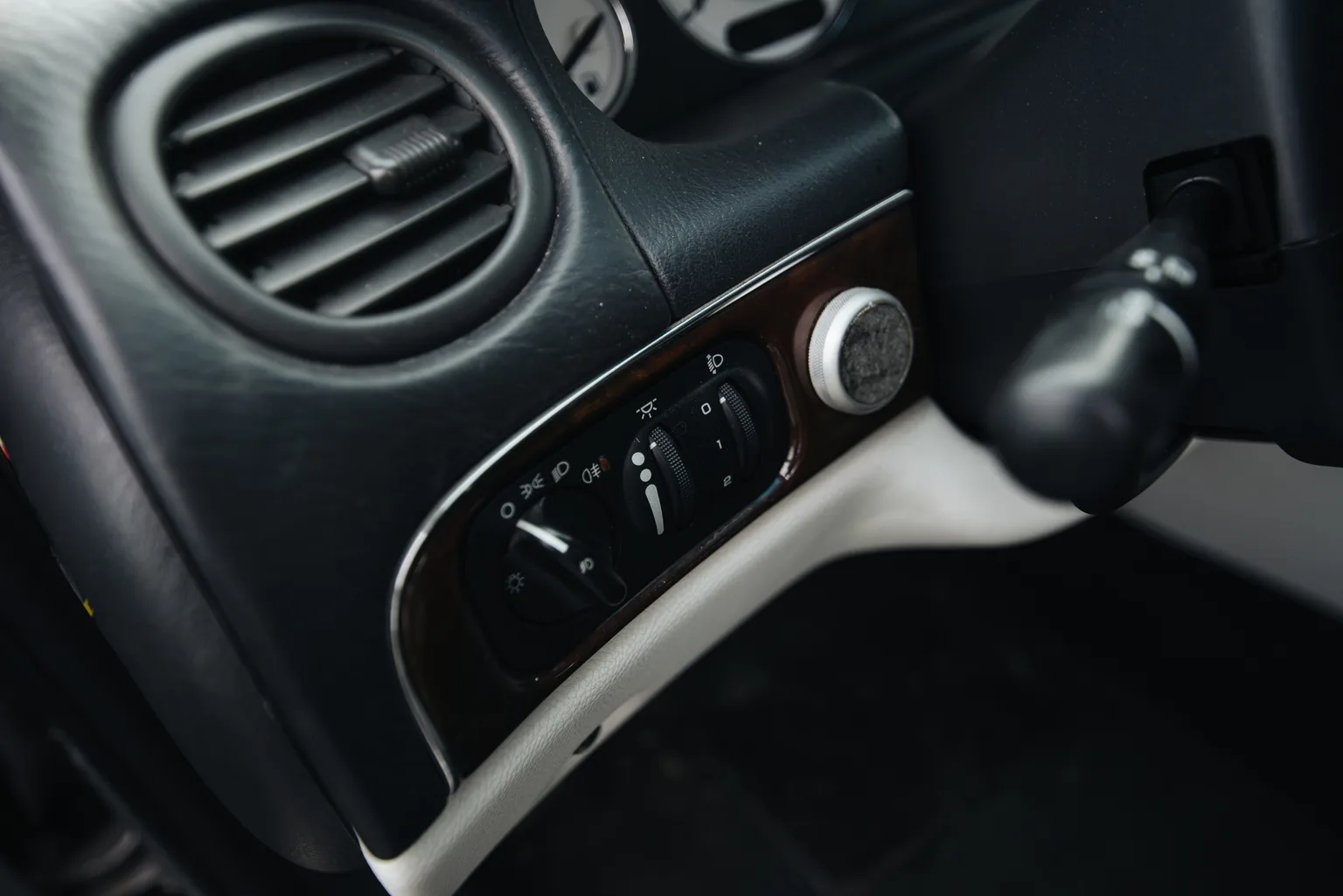 Close-up of a hand using car audio controls on the steering wheel