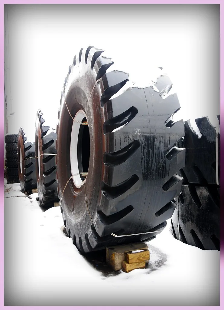 Close-up of a winter tire with deep tread on packed snow