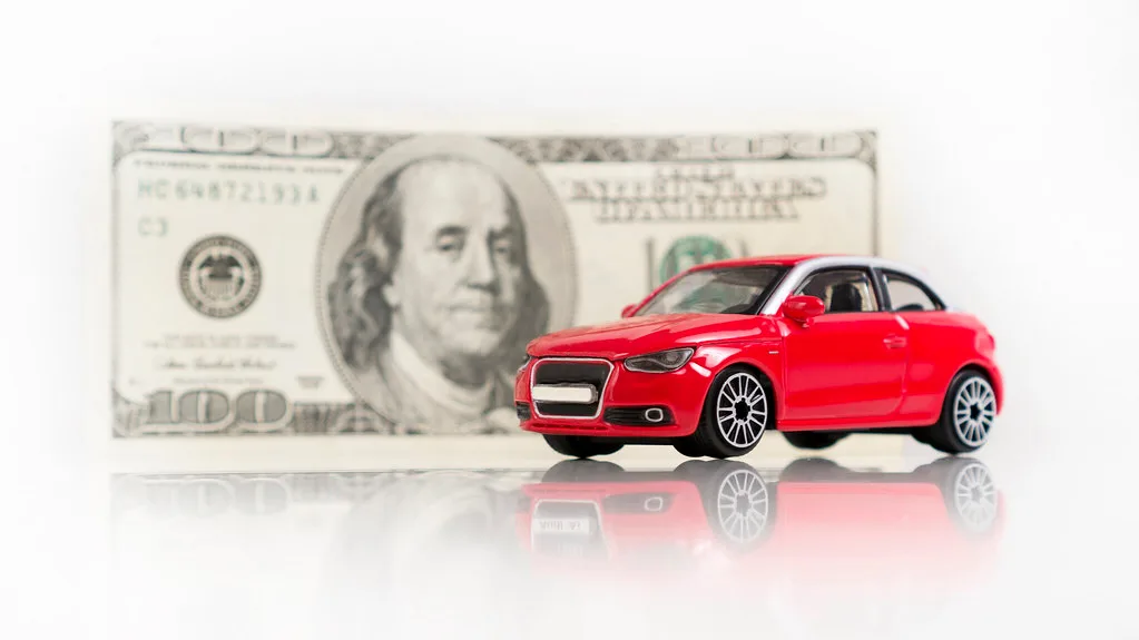 Hands comparing car finance figures with a calculator, paperwork, and car keys