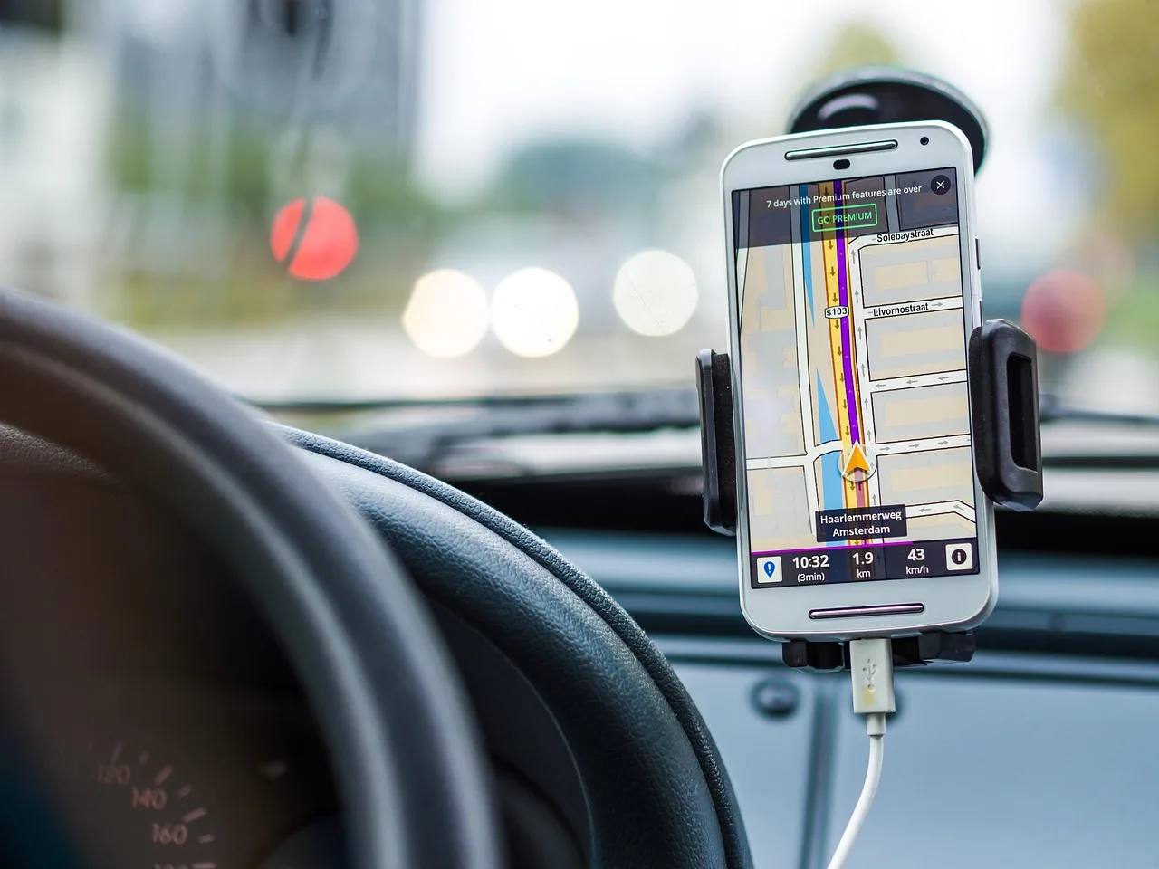 Budget phone mount on a car dashboard with a hand placing a phone into it