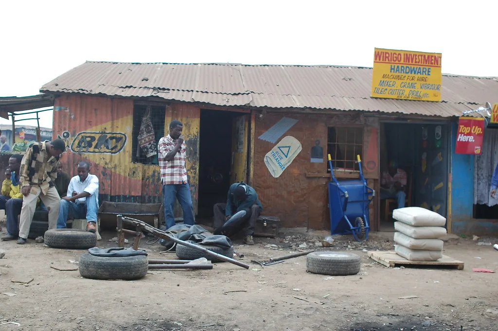 Hands inserting a tire plug into a punctured tire tread with repair tools nearby
