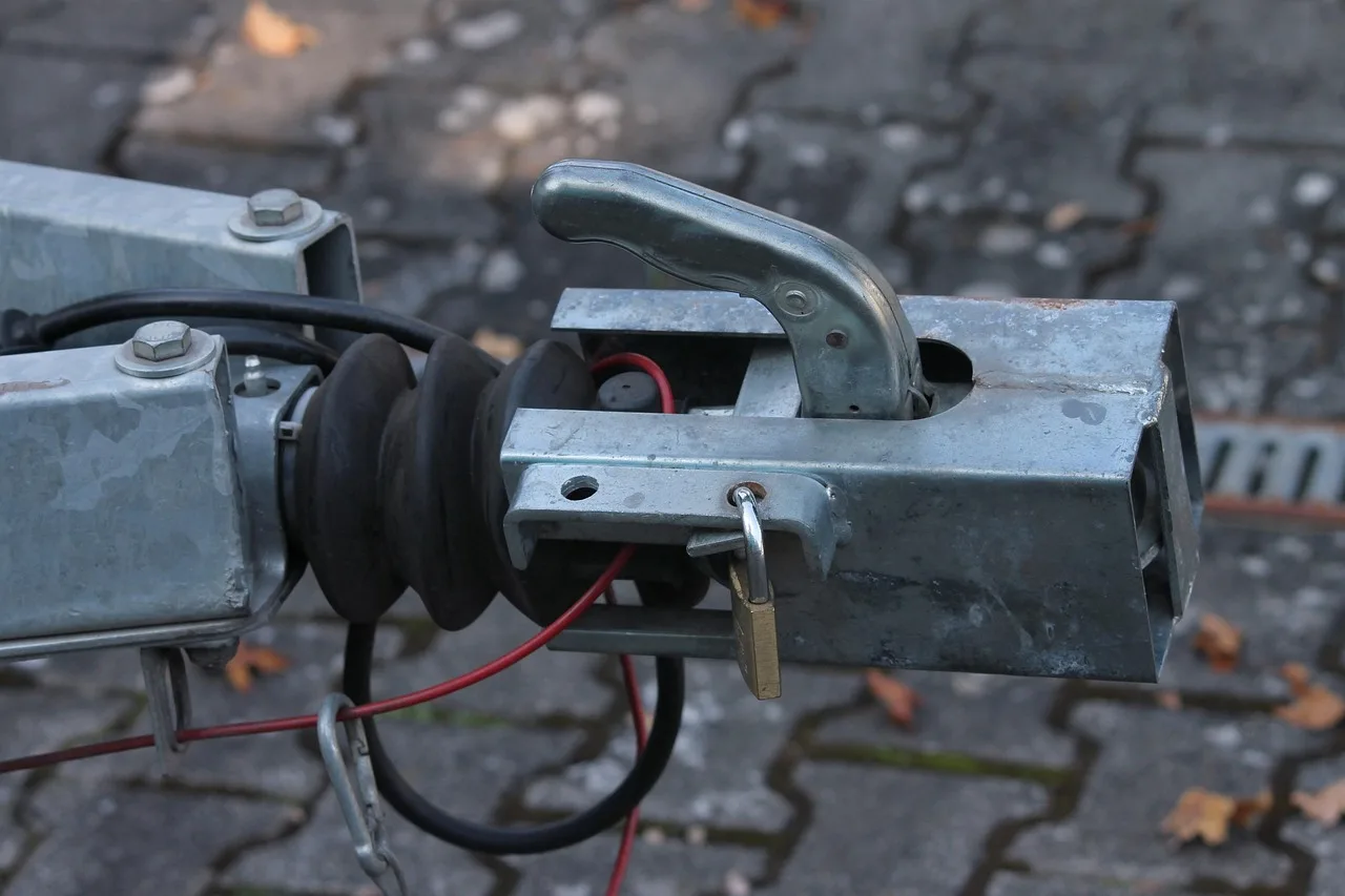 Trailer hitch accessories laid out beside a midsize SUV in a driveway