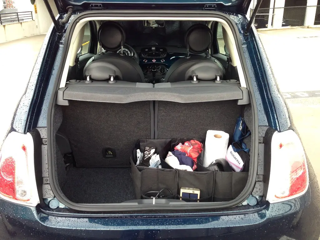 SUV trunk with grocery bags, a cooler organizer, and anti-slip storage bins in natural light