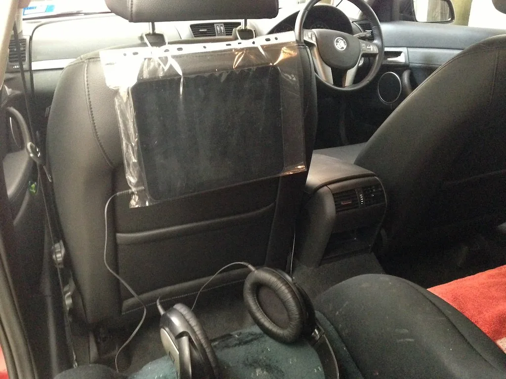 Close-up of a hand tightening a car seat belt path during installation
