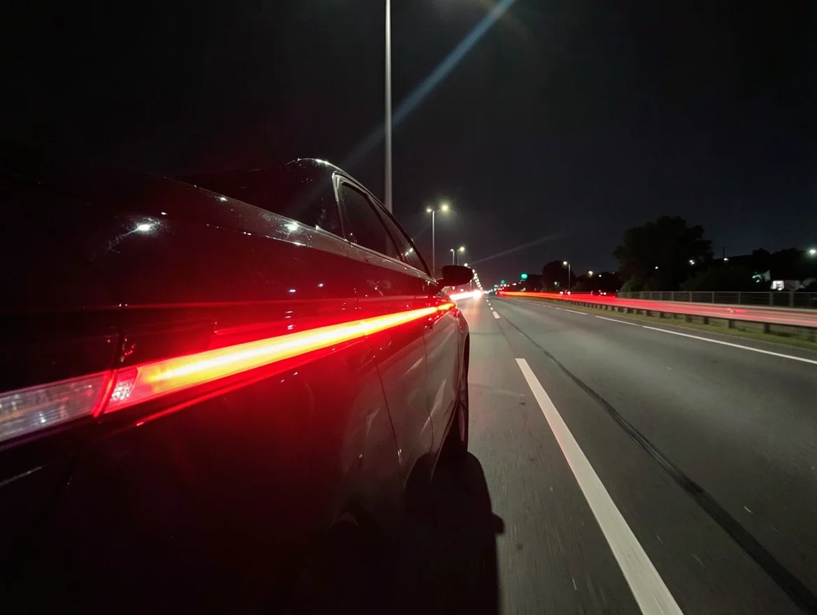 Car taillights glowing bright red at night on a highway, showing why rear light visibility matters for safety