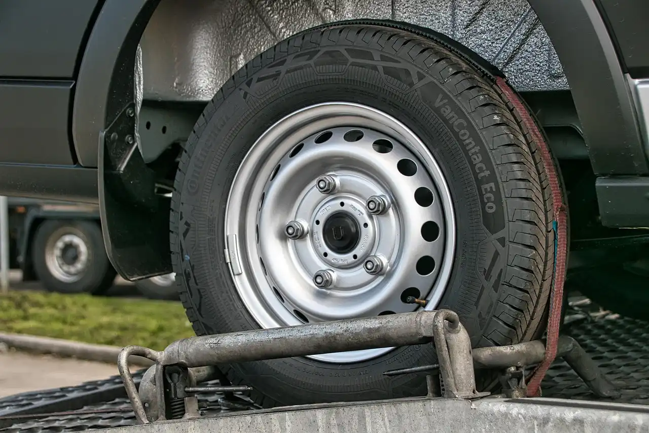 Car towing accessories laid out by the trunk, separated into emergency kit and trailer gear.