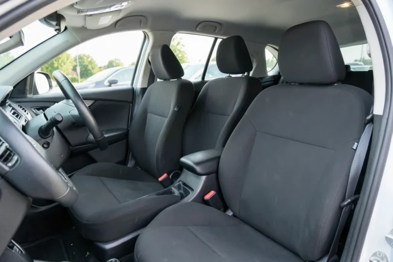 Black seat covers installed on the front seats of a compact sedan interior