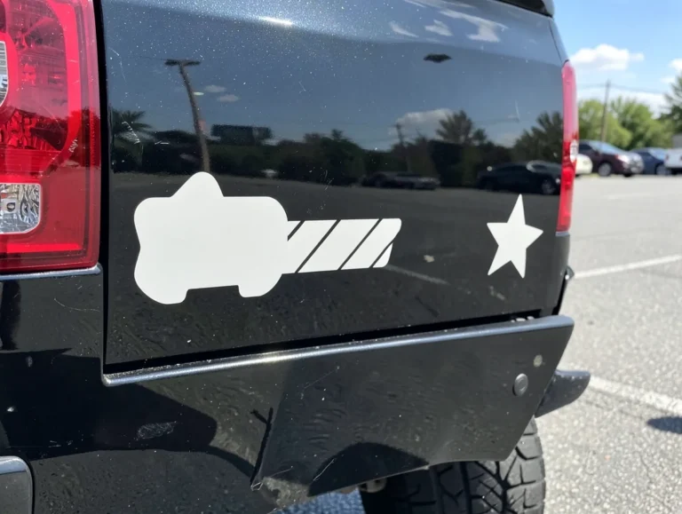 Simple silhouette vinyl decals applied to the rear bumper of a black pickup truck