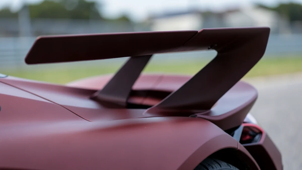 Close-up of a hypercar's rear wing and diffuser fins, showing the aerodynamic design used to stabilize a car at extreme speed