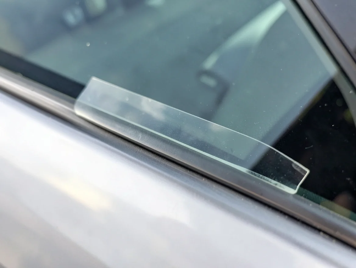 Close-up of clear safety film laminate applied to the edge of a car window