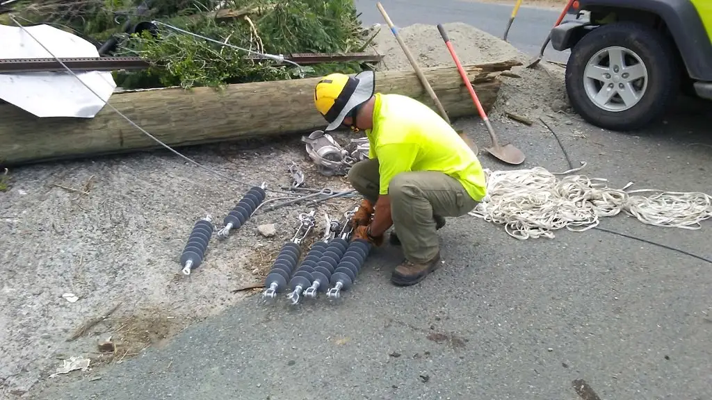 Gloved hands checking transmission fluid dripping into a drain pan under a car