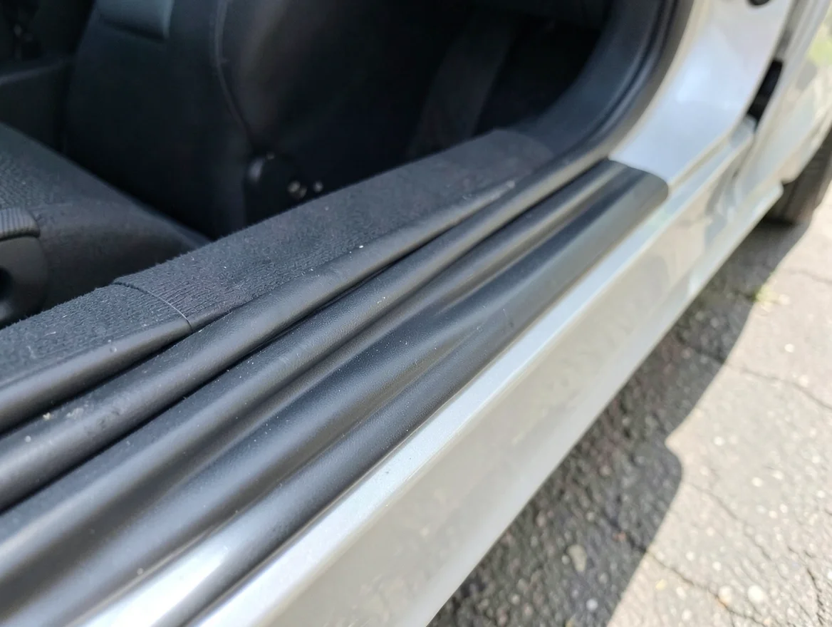 Close-up of new black rubber weatherstripping seal installed along a car door edge