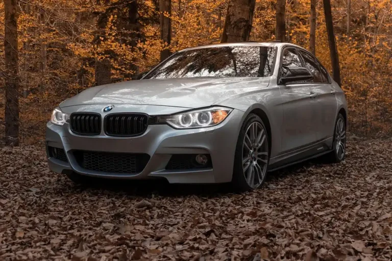 2013 BMW 328i on a lift with front-end parts removed in a repair shop