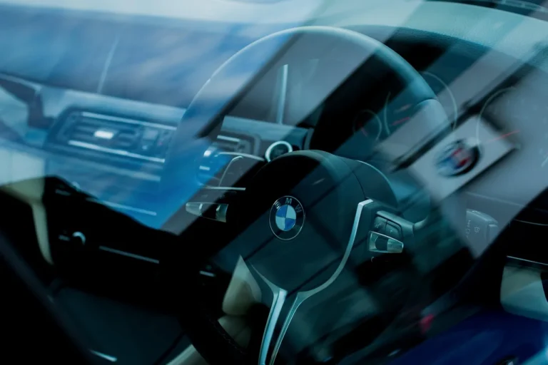 2026 BMW 540i M Sport parked on a wet mountain road at sunset