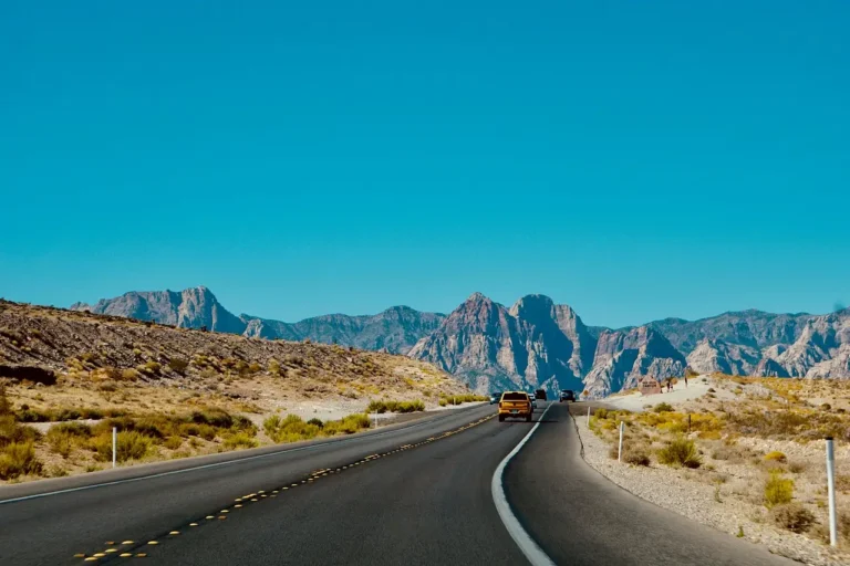 Road trip essentials on a car seat: smartphone navigation, jump starter, and power bank
