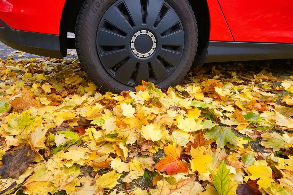 All-season tires, a calculator, and a repair estimate beside stacked tires in a driveway