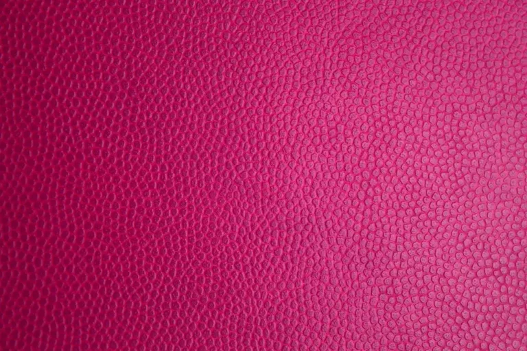 Detailer wiping a tan car leather seat with a microfiber pad in natural light, showing Armor All Leather Care Gel use