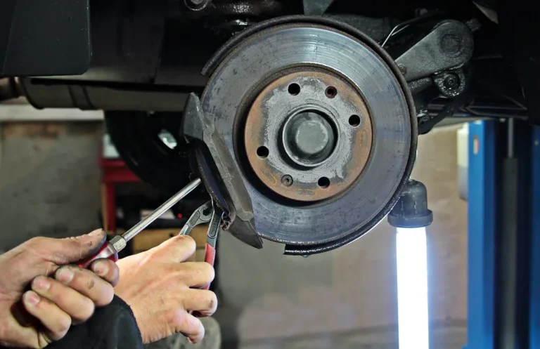 Auto services business setting with a technician, tablet, and electric vehicle in a bright garage