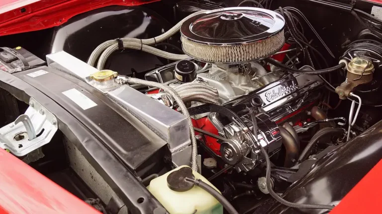 Automotive technology student and instructor inspecting a car engine in a training garage