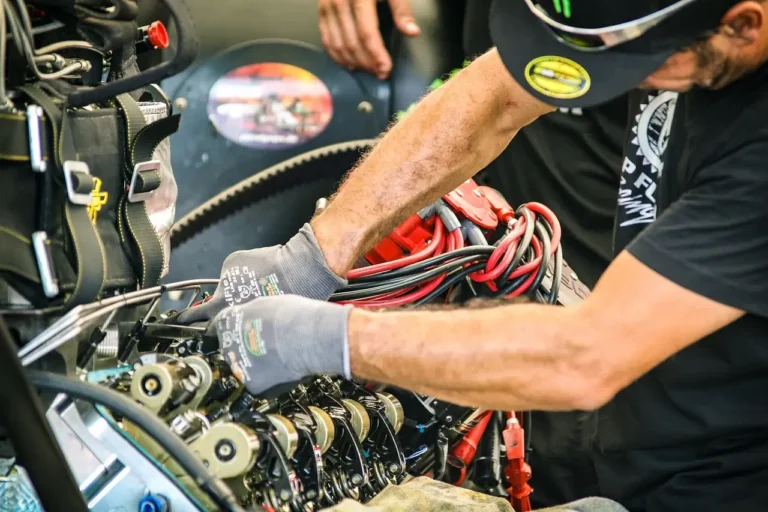 Automotive technology students and technicians work around an electric vehicle in a bright garage.