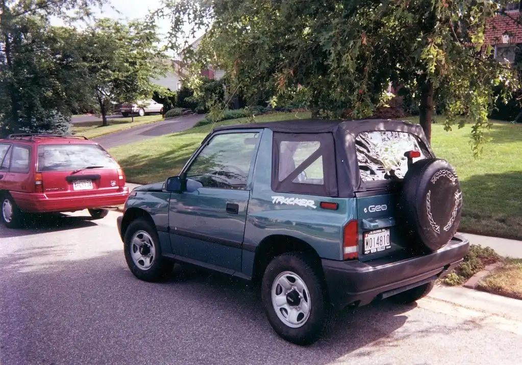 Two SUVs on a wet mountain road, with an AWD crossover on pavement and a 4WD pickup near a dirt trail