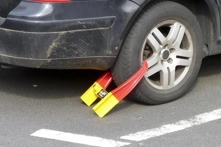 Car protection scene with a steering wheel lock, smartphone tracker, and parked sedan at dawn