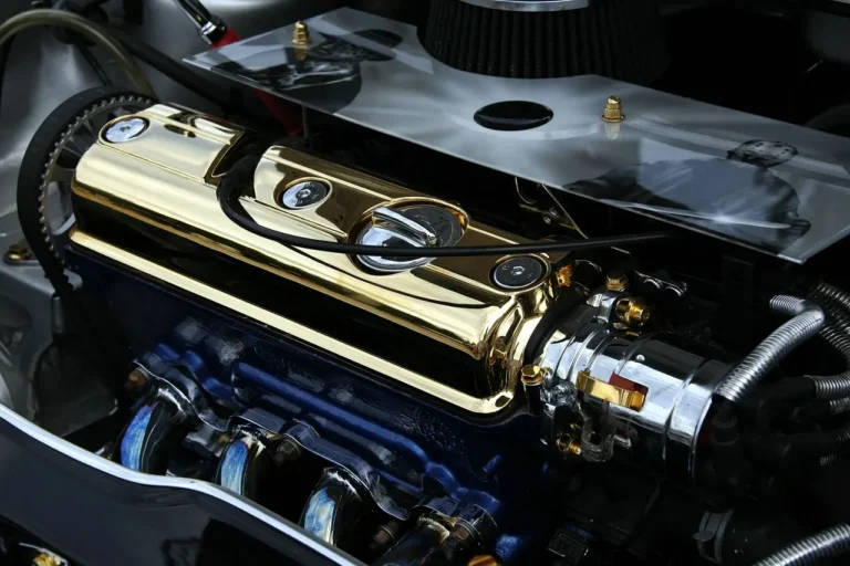 Car engine bay inspected in daylight with gloved hands checking key components for longevity
