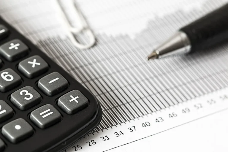 Person reviewing car finance paperwork and budget figures at a kitchen table