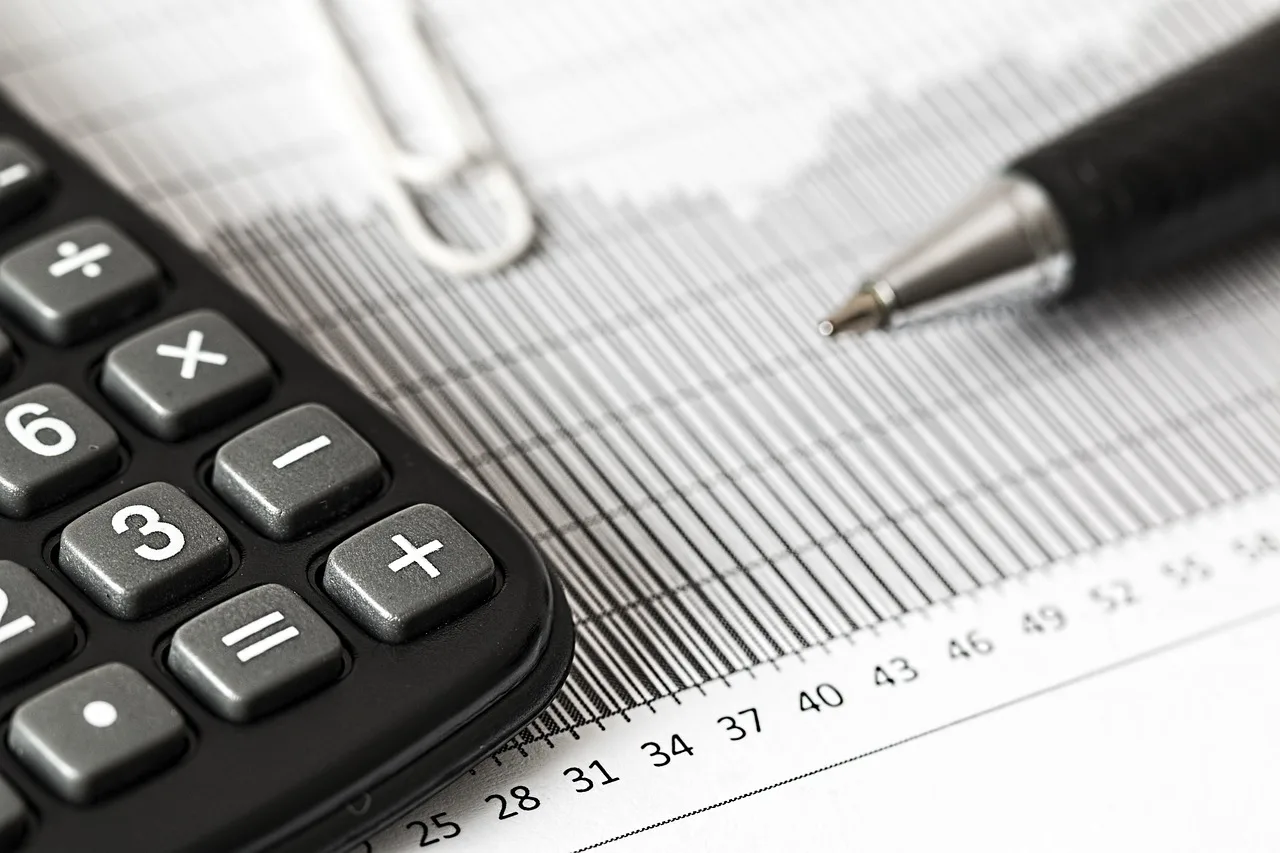 Person reviewing car finance paperwork and budget figures at a kitchen table