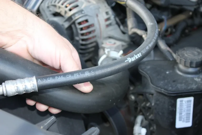 Car hose kits, clamps, and tools arranged beside an open engine bay