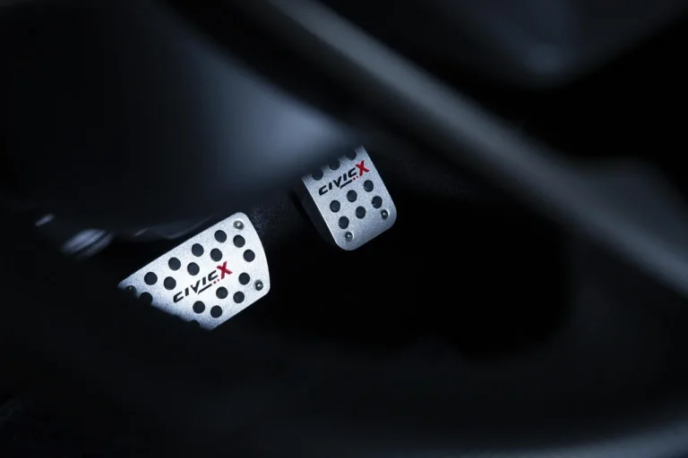 Car pedal covers being installed on brake and accelerator pedals in a sunlit car interior