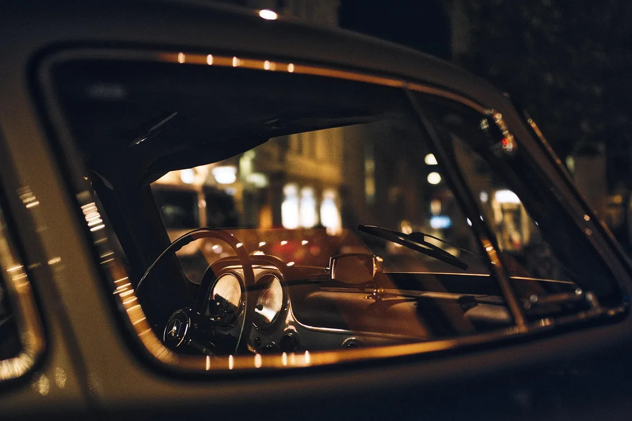 A chauffeur opens a black sedan door for a traveler on a Los Angeles street with palm trees.