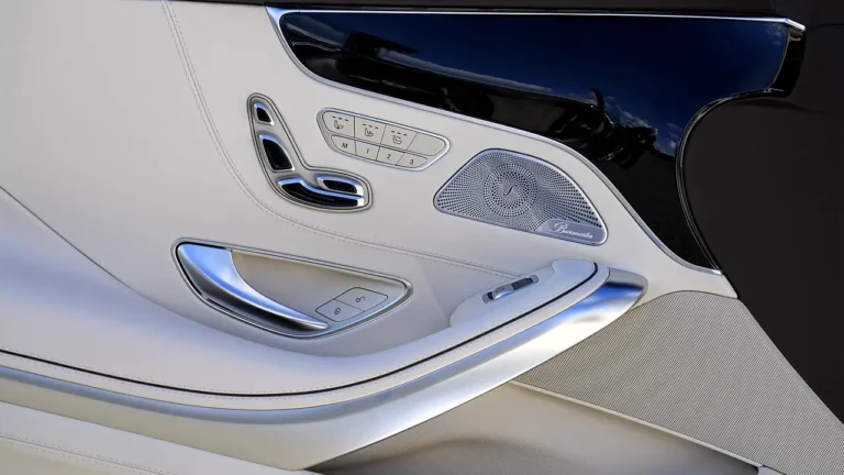 Person comparing car speakers and a spec sheet inside a modern car with natural light