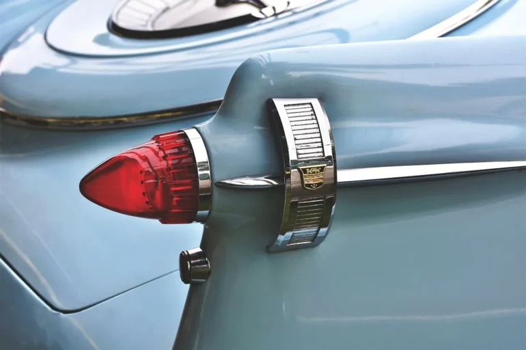Car owner checking a sedan's taillights in warm natural light