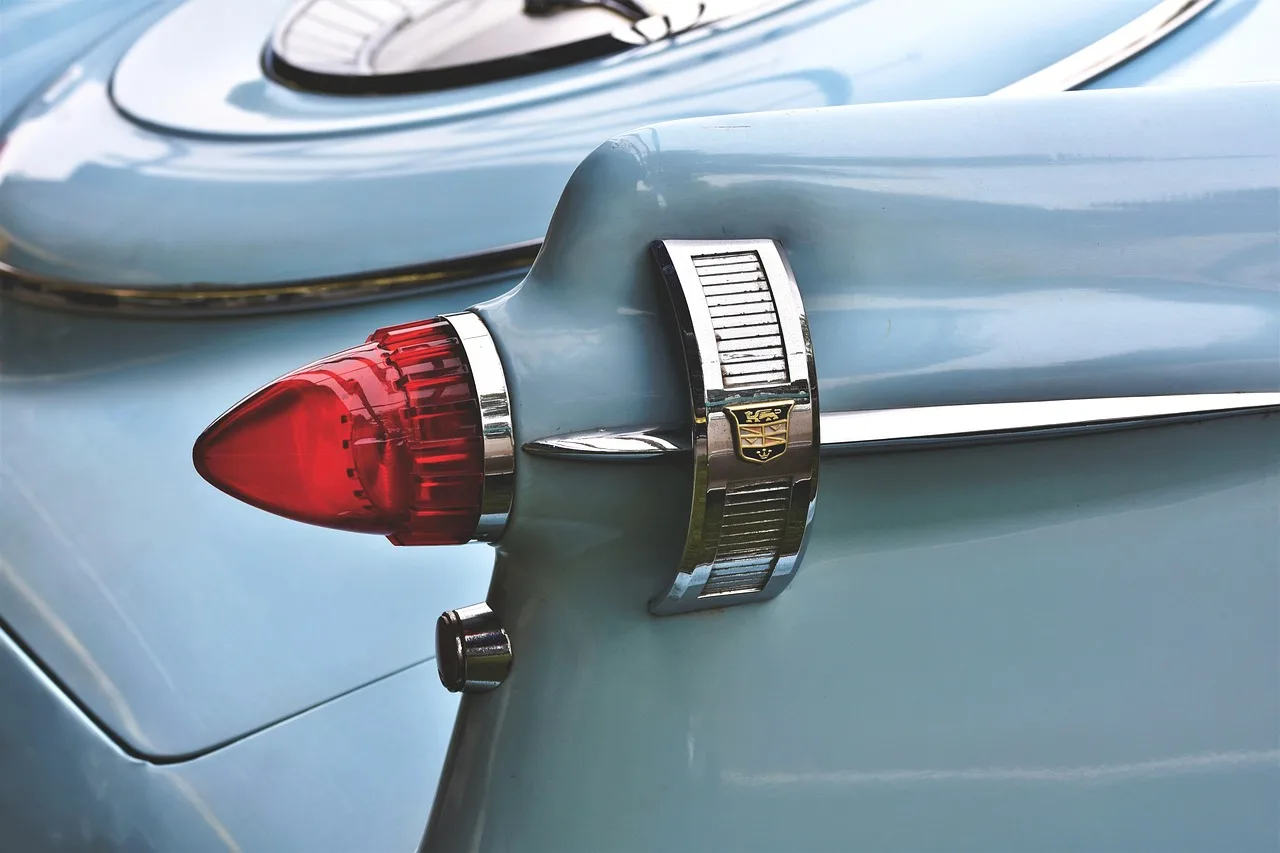 Car owner checking a sedan's taillights in warm natural light