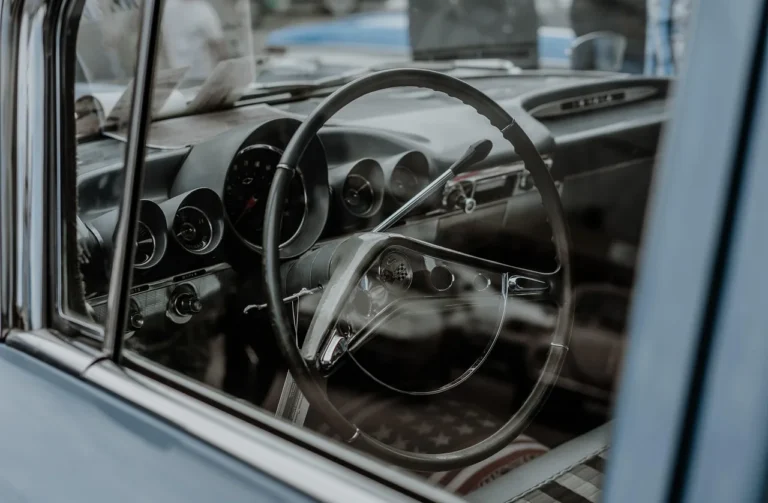 Car interior with dressing spray bottles, microfiber towel, and dashboard surfaces in natural light