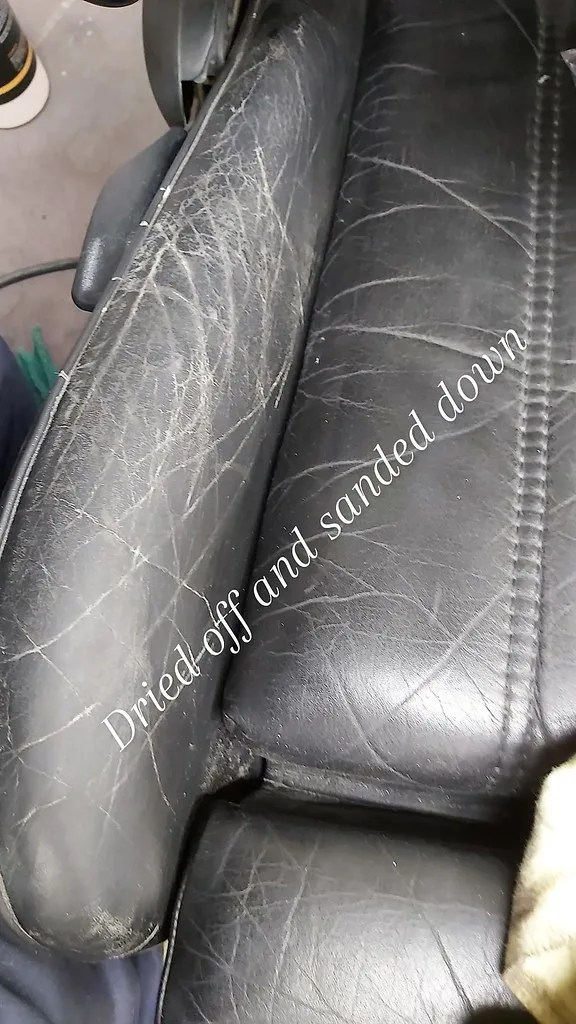 Hands applying filler to a cracked leather seat panel with repair tools nearby