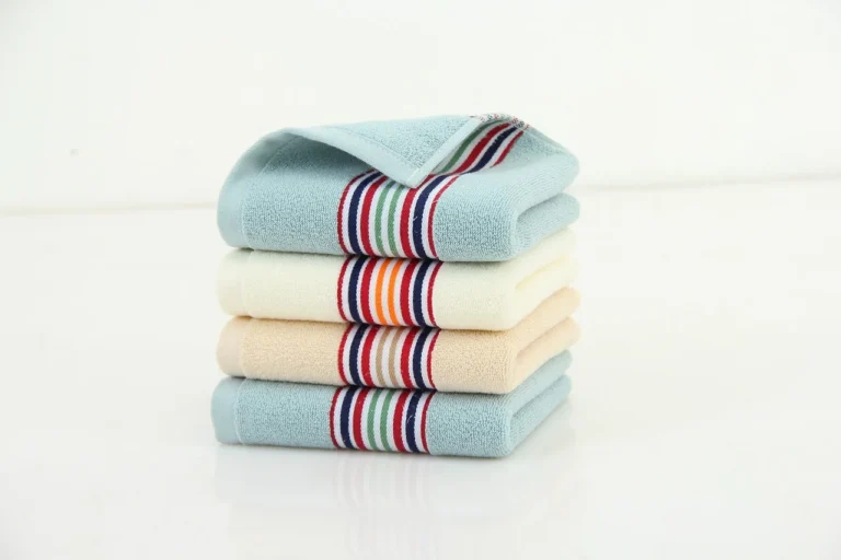 Three microfiber towels on a garage workbench beside a car hood in natural light