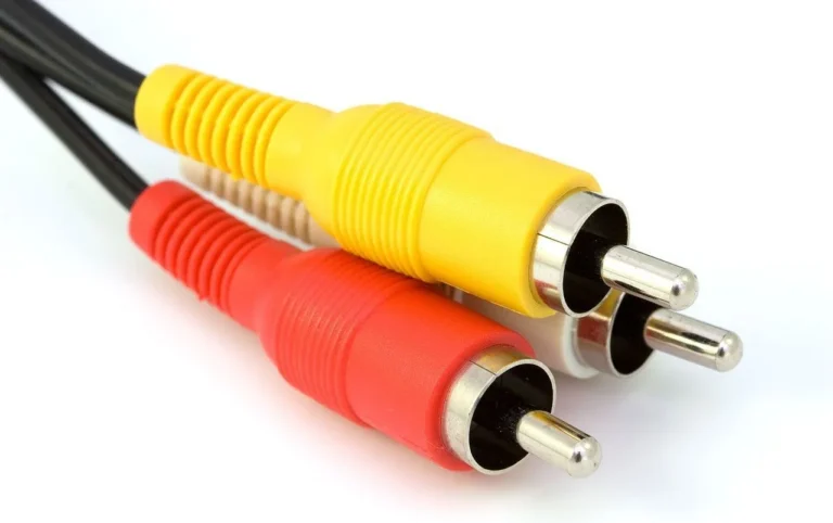 Car audio installer comparing two RCA cables beside an amplifier on a workbench