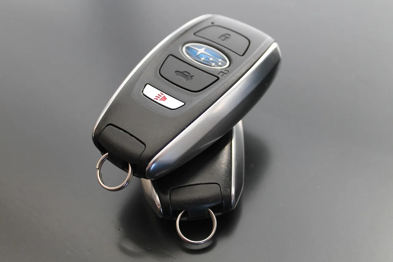 Spare car key storage options arranged beside a parked SUV in a driveway
