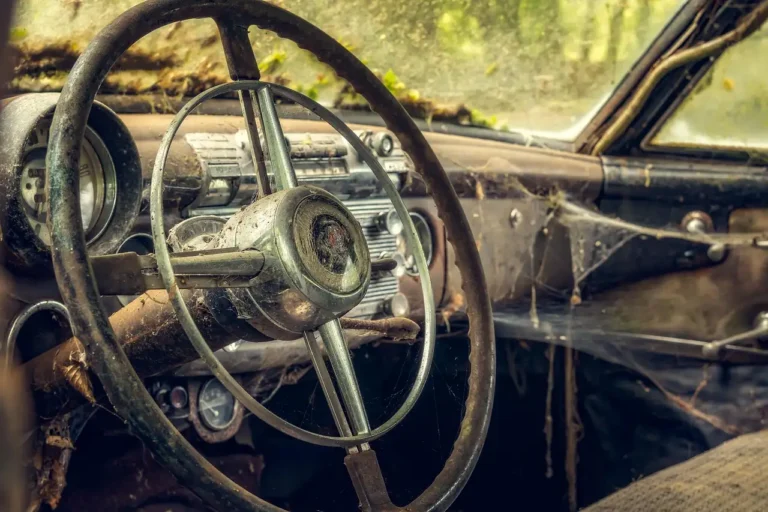 Two steering wheel covers on a car seat beside a steering wheel and driver’s hands