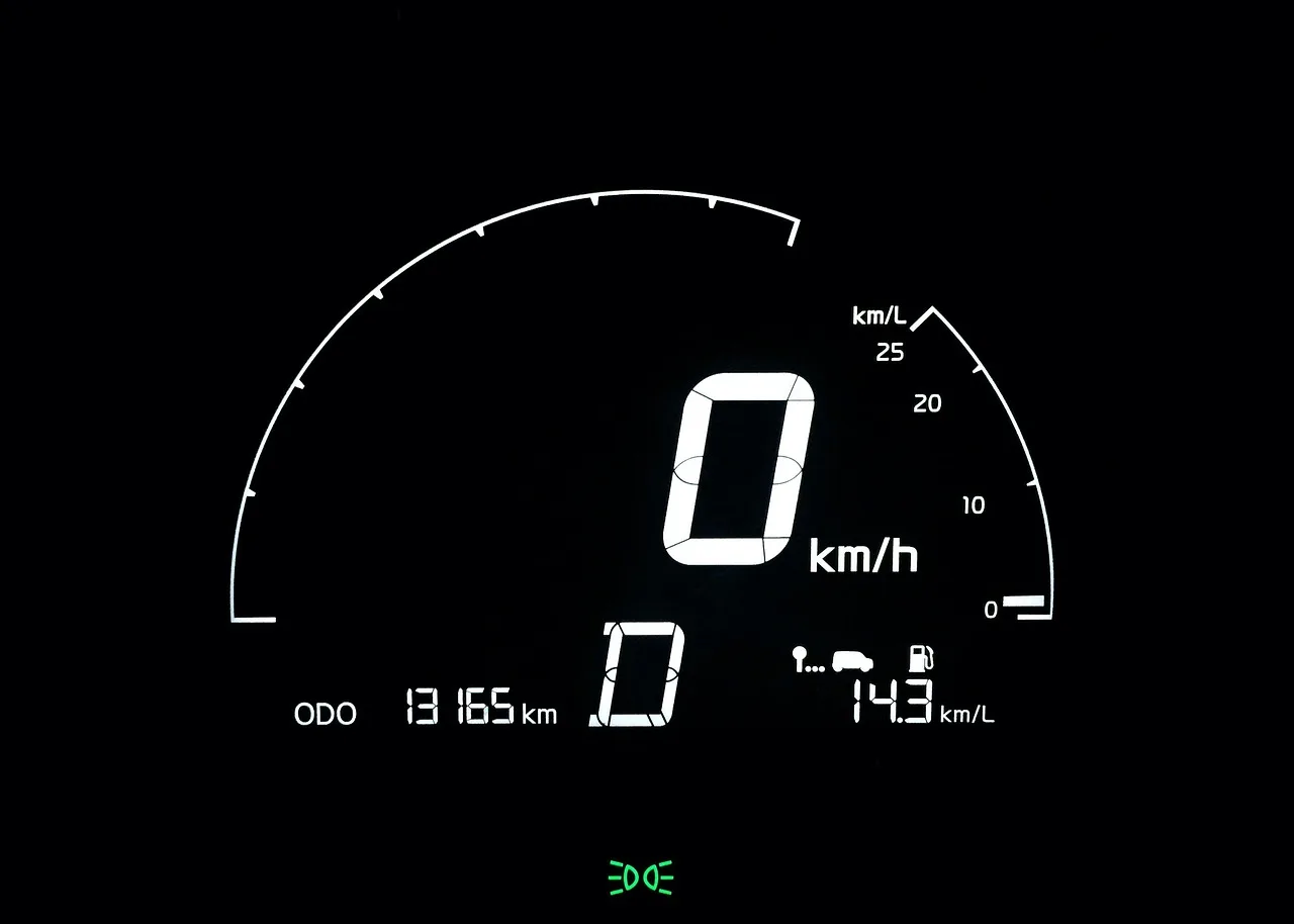 Two universal digital speedometers mounted on a car dashboard in natural daylight