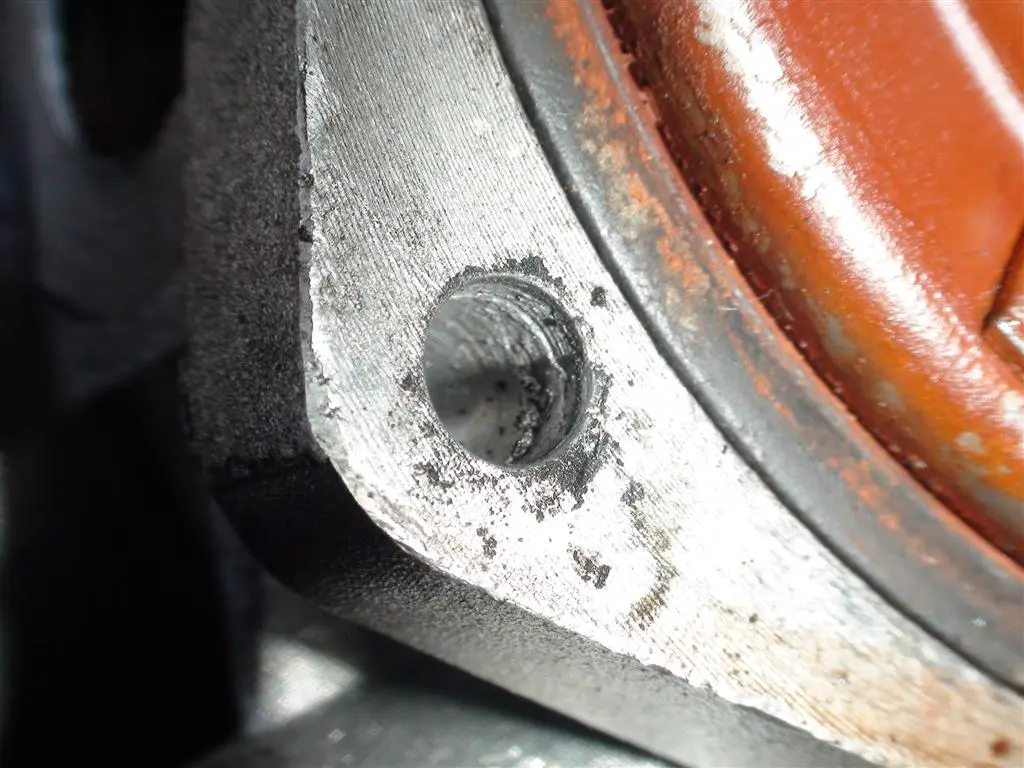 Close-up of a mechanic using a diagnostic scanner beside a crowded BMW engine bay