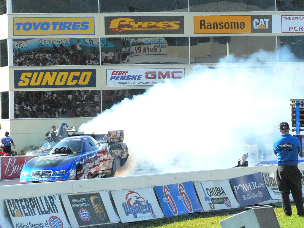 Mechanic checking transmission fluid and underbody on an automatic car after a burnout