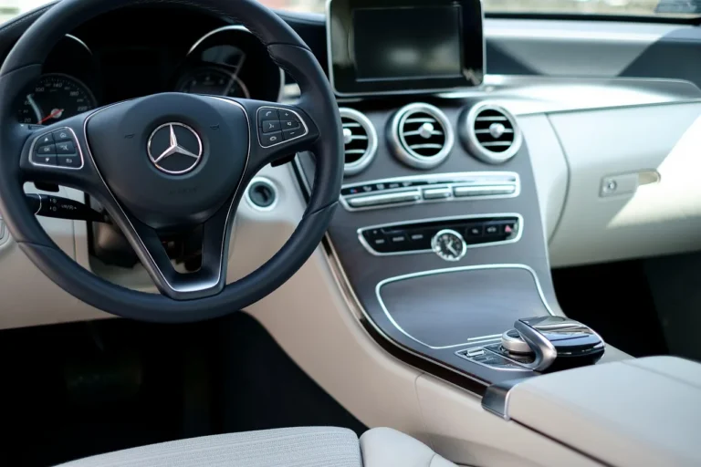 Modern car interior with driver adjusting audio settings beside visible speakers and subwoofer.